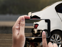 Hands holding a smart phone taking a photo of a crash