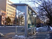 DC Bus Shelter Program - DC bus shelter in front of an apartnent building with melting snow on the nearby ground