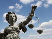 Civil Rights image of classic Greek female sculpture holding the scales of justice in front of a blue, clouded sky