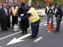 Pavement Markings - Photo of DDOT worker showing people how to spray pavement marking arrow