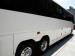 Tour Bus Parking - side view of white tour bus from back to front